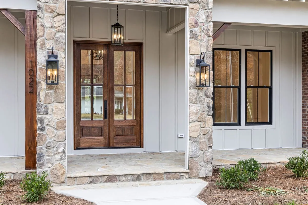 Wood-and-glass double entry door framed by stone columns