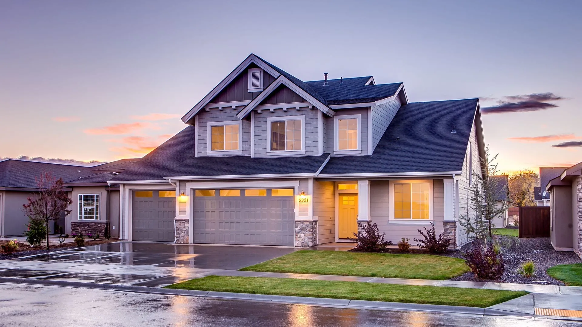Craftsman-style home at twilight with warm light glowing through new energy-efficient windows